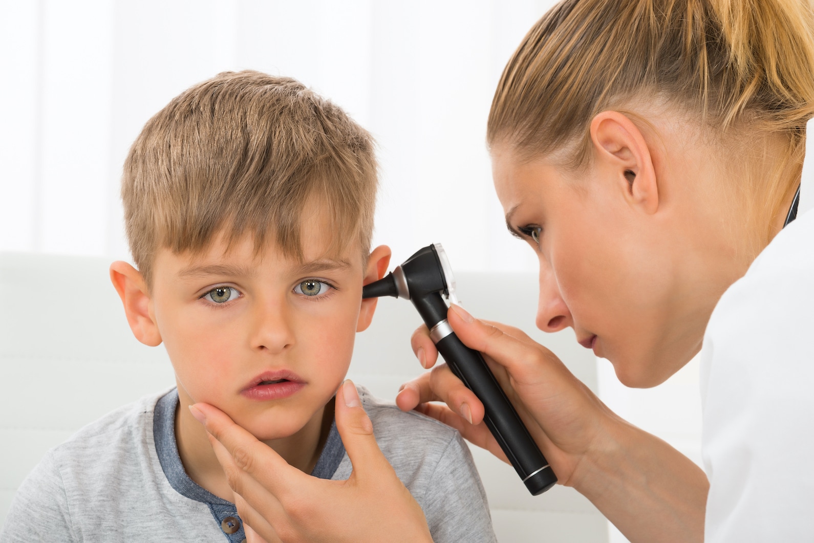 Doctor checking child's ear