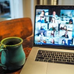 view of a laptop with a meeting and multiple people on the screen