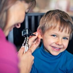 Young boy getting his ears checked by a doctor