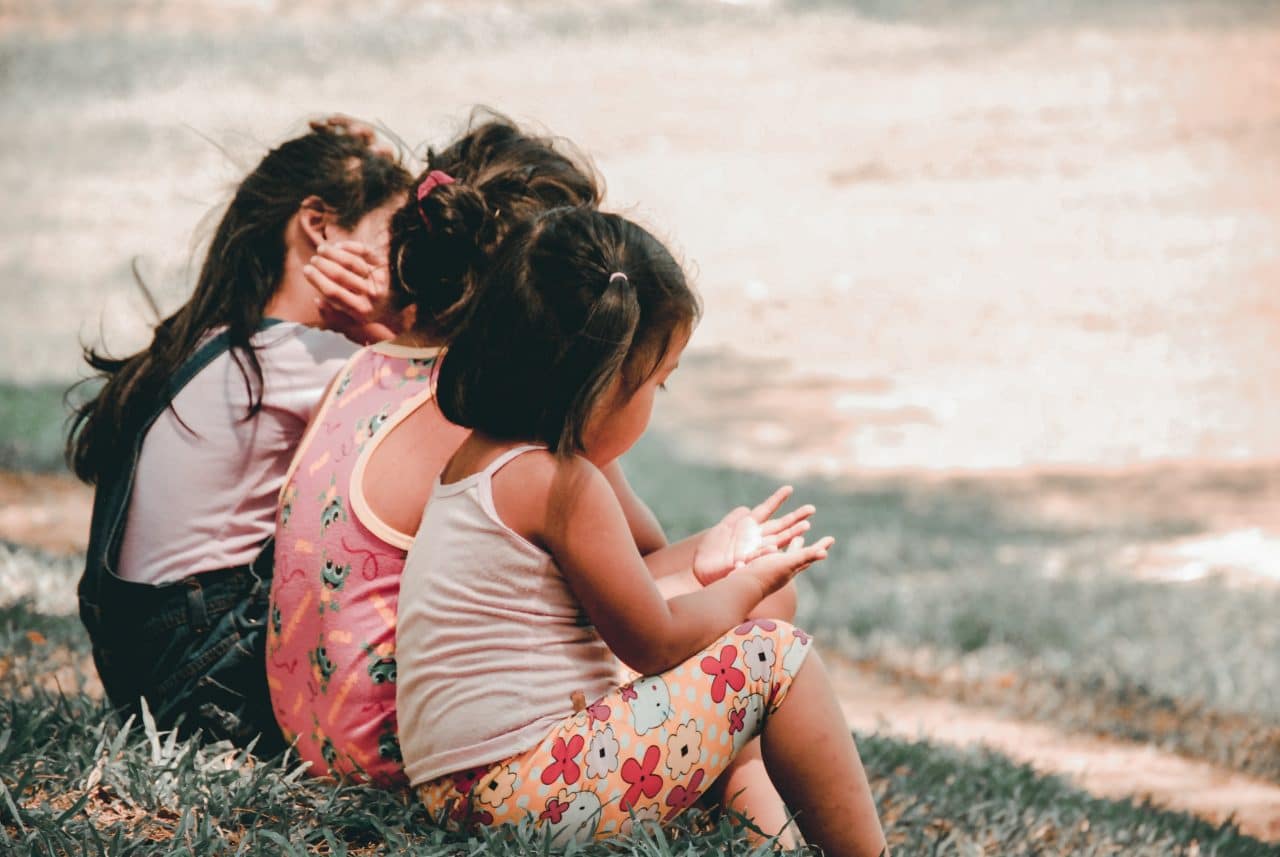 Does Your Child Need Ear Tubes? Children sitting together outside.
