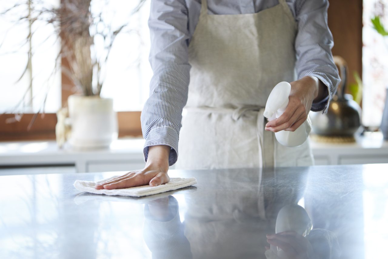 A person wipes down their kitchen counter