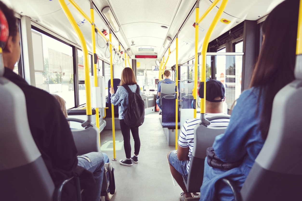 View from behind of people sitting on a public bus.
