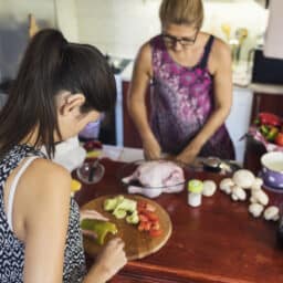 Young woman with hearing aid preparing food with her family at home
