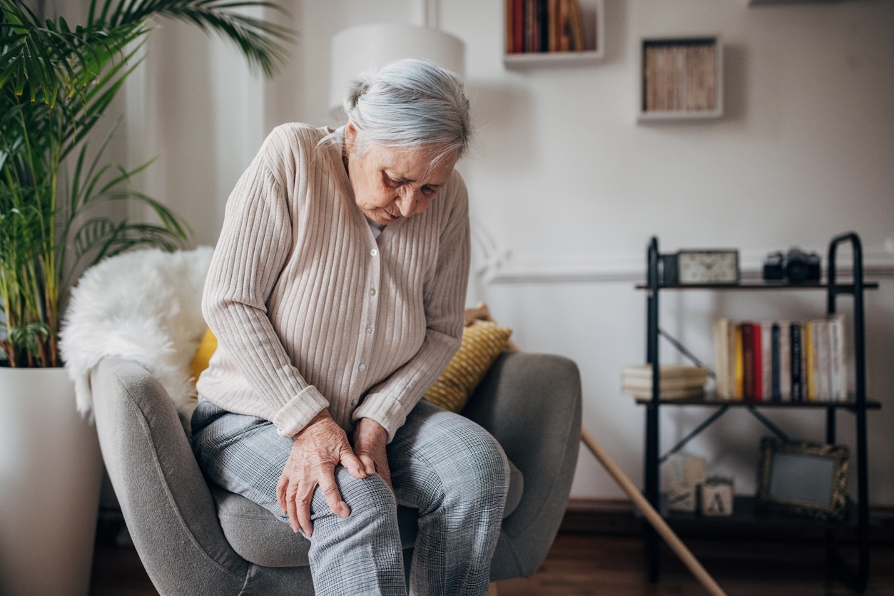 Woman with arthritis holding her knee .