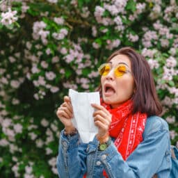 Woman about to sneeze into a napkin in the park