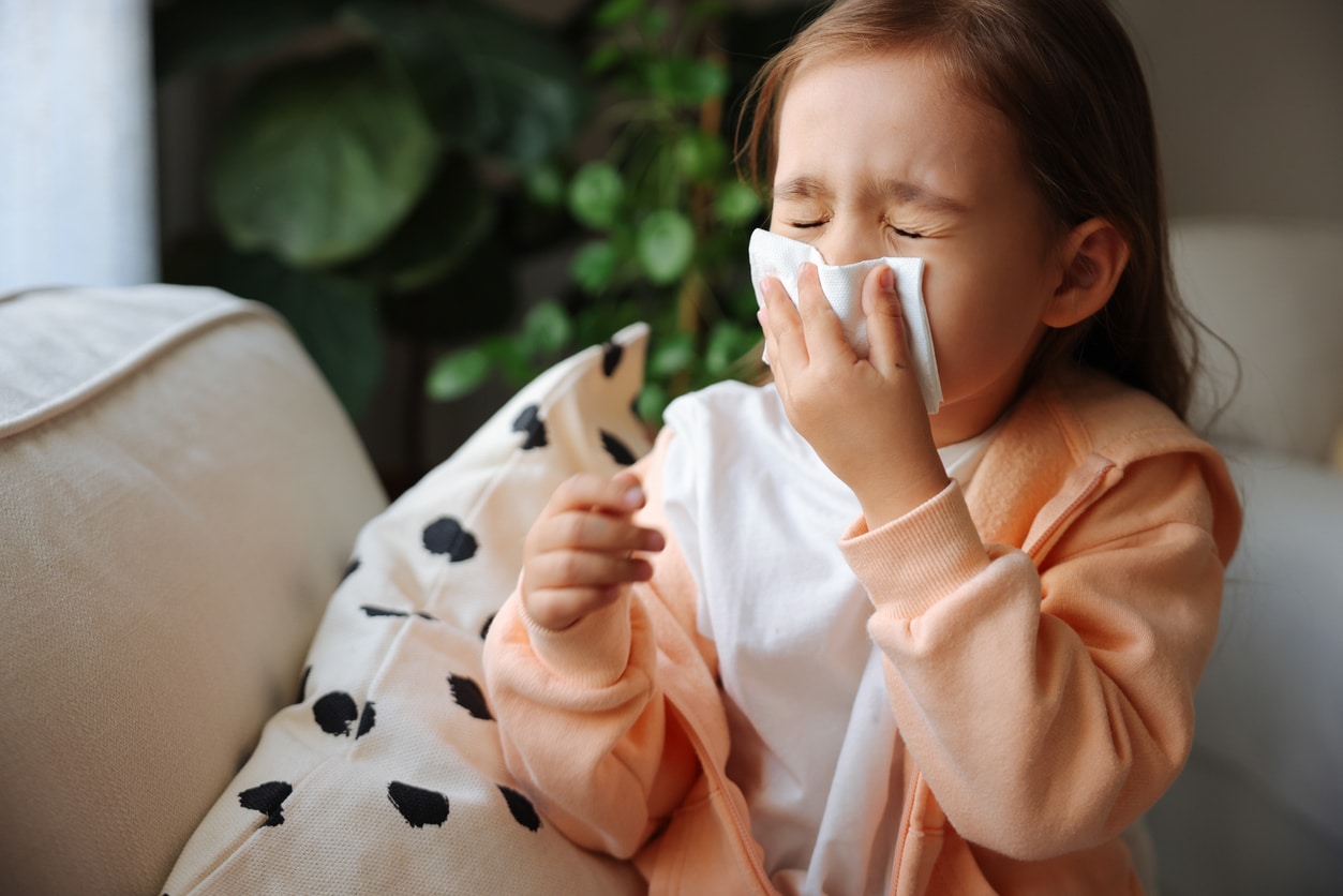 Young girl blows nose
