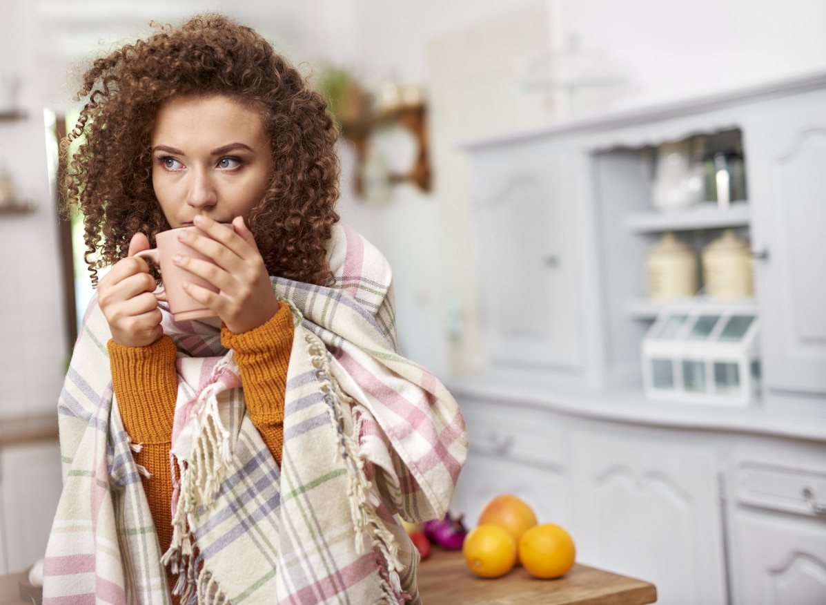 Woman with a cold drinking a hot cup of tea.