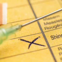 Close up of a shingles vaccine card and needle