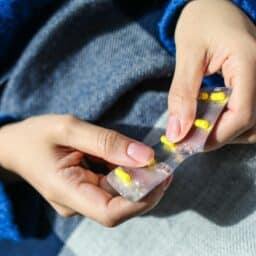 Person with allergies pops an antihistamine pill out of the packet.