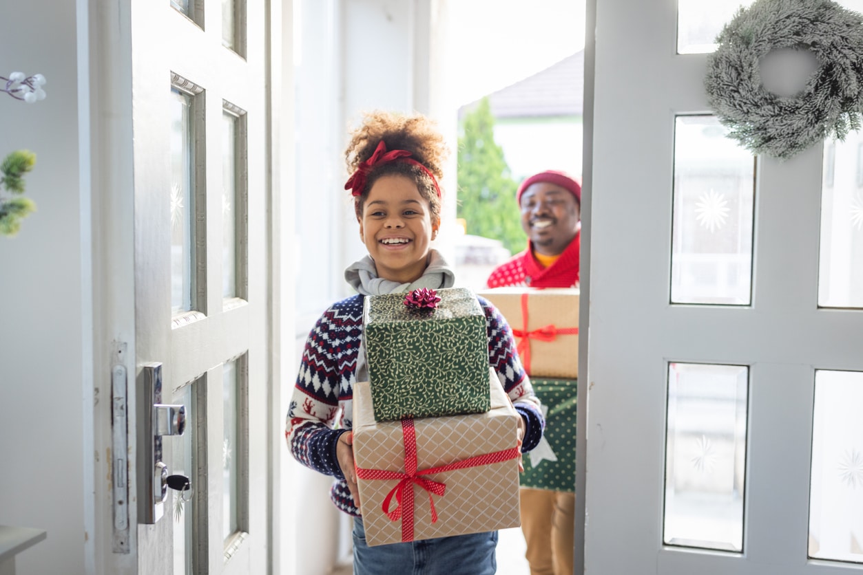 Family returning home with wrapped Christmas presents