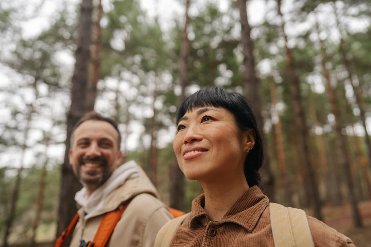 Smiling couple on a hike in the woods