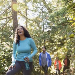 Four people hiking through the woods in Oregon.