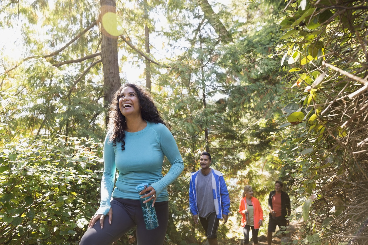 Four people hiking through the woods in Oregon.