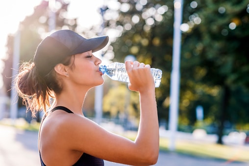 Drinking fresh water on a hot day to stay hydrated