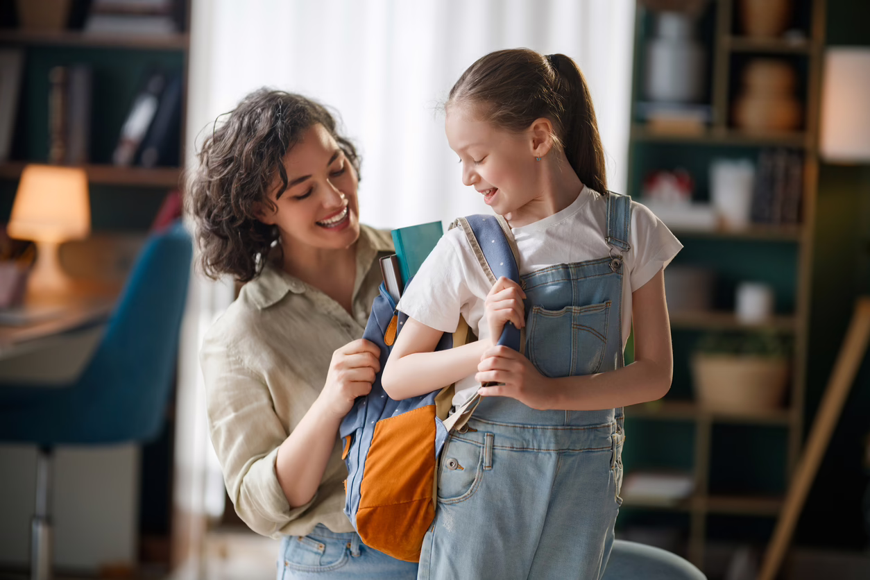 Parent helping her daughter get ready for school